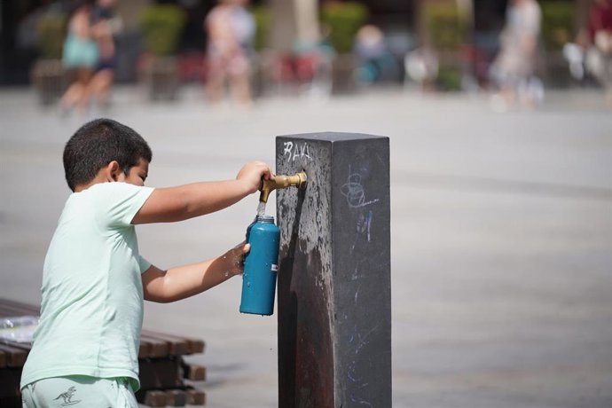 Archivo - Imagen de archivo de un ni&ntilde;o que llena una botella de agua.