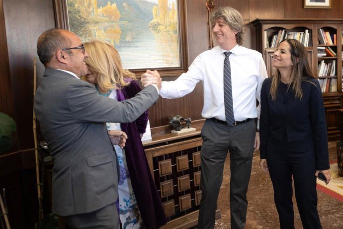 El procurador del PSOE en las Cortes de Castilla y León, Carlos Martínez (2d), saluda al teniente de alcalde de Soria, Luis Rey (1i), durante el acto de renuncia de su cargo de alcalde de Soria.
